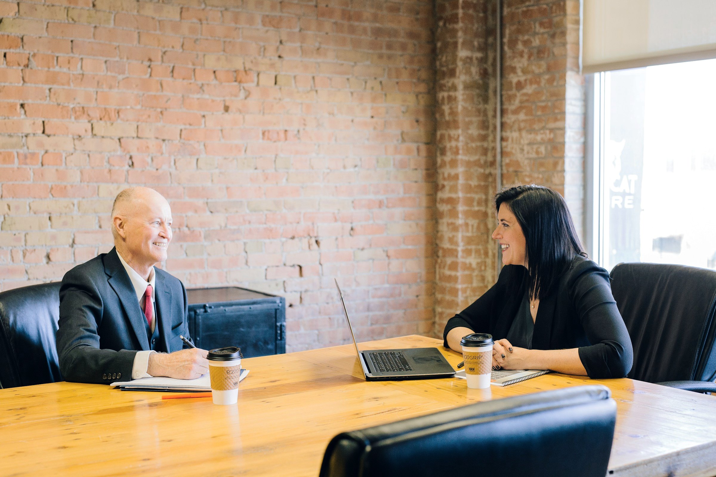 Two colleagues talking across a conference table