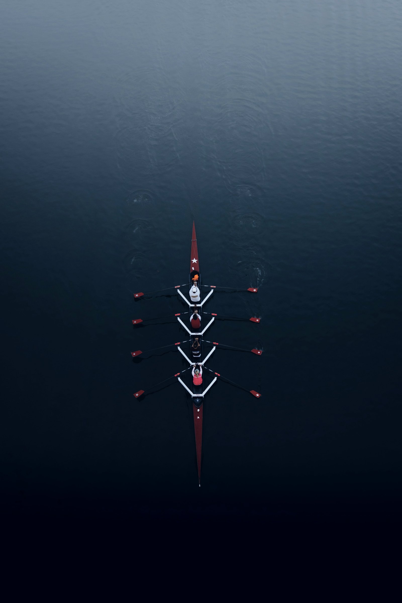 Rowing crew seen from above on dark water
